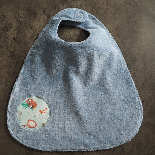 Grand bavoir bleu avec motifs d'animaux