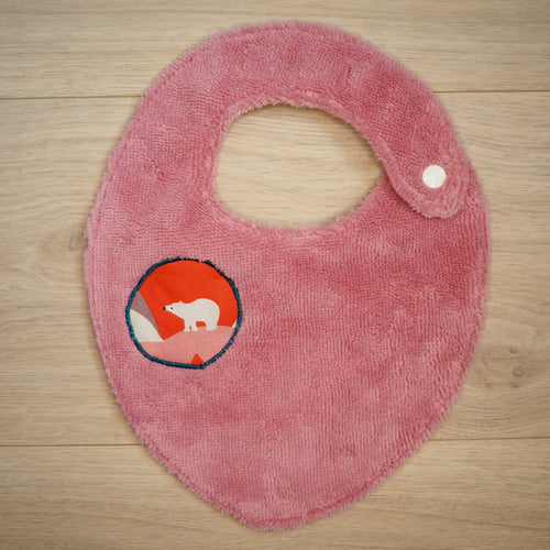 bavoir rose avec des motifs de montagnes colorées et d'ours