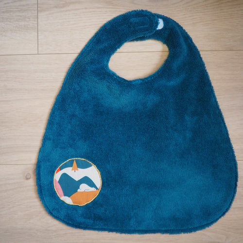 grand bavoir pour réglable pour enfant. Bleu avec des motifs d'ours et de montagnes colorées