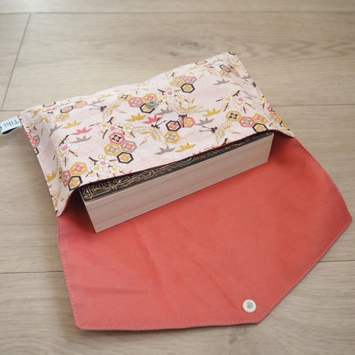 couvre livre rose aux motifs de grues
