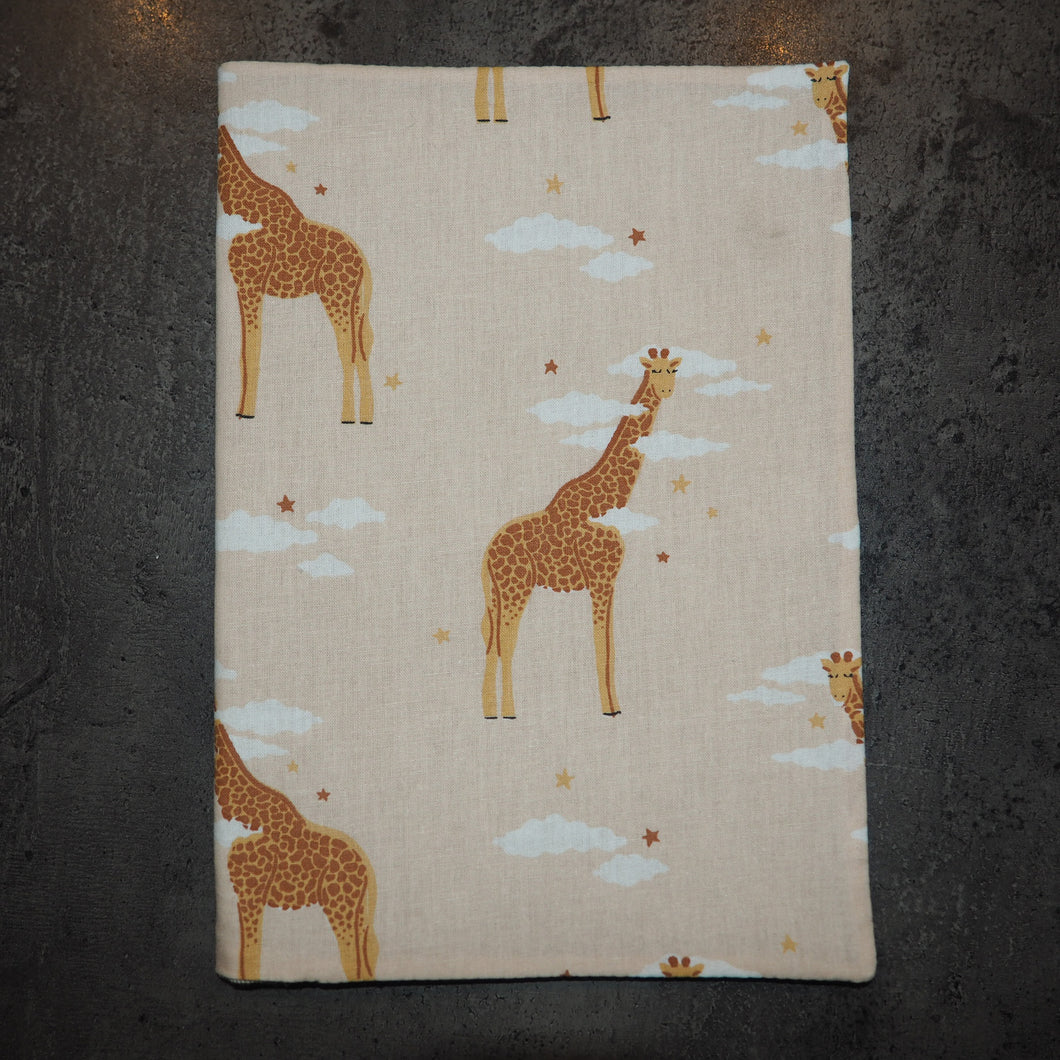 Couverture pour carnet de santé éco-friendly aux motifs girafes, étoiles et nuages sur fond rosé. 